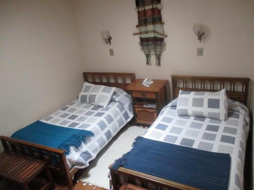 a bedroom with two beds and a table at Hotel Boutique Las Azucenas in Constitución