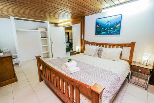 a bedroom with a large bed with a wooden frame at A Lure - A 2-minute walk to the pristine beach! in Agnes Water