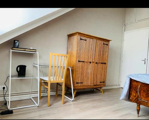 a bedroom with a desk and a wooden cabinet and a chair at Chambre privée in Angers