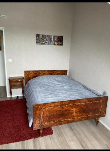 une chambre avec un grand lit en bois dans une pièce dans l'établissement Chambre privée chez l'habitant, à Angers