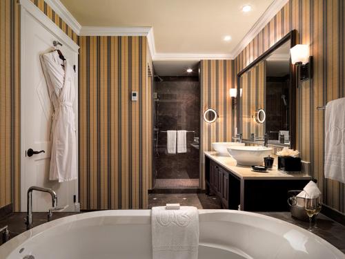 a bathroom with a tub and two sinks and a shower at Oak Bay Beach Hotel in Victoria