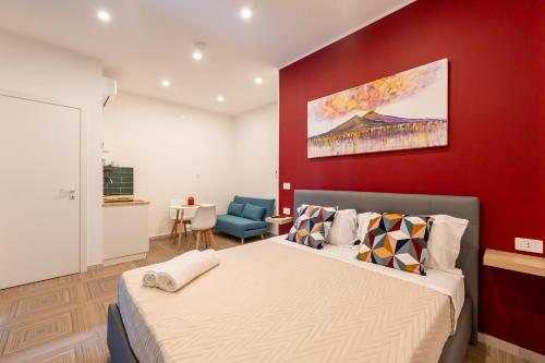 Un dormitorio con una cama grande y una pared roja. en R&D Scassacocchi apartments 15, en Nápoles