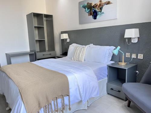 1 dormitorio con 1 cama grande y 1 silla en Serenity Suite With free Wi-Fi and Swimming pool, en Dar es Salaam