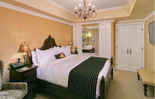 a bedroom with a large bed and a chandelier at Oak Bay Beach Hotel in Victoria
