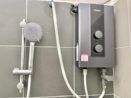 a bathroom with a shower with a hair dryer and a shower at Homestay Gambang Modern vintage OZZY GUESTHOUSE in Gambang