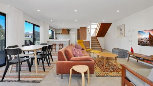a living room with a couch and a table and chairs at Nina's Place in Sawtell