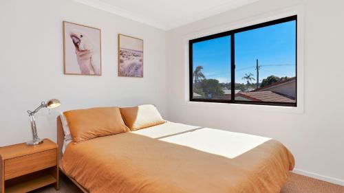 a bedroom with a bed and a window at Nina's Place in Sawtell