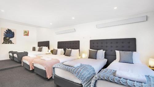 a bedroom with three beds and two chairs at Blackwood Manor Retreat in Braemar