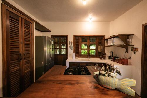 uma cozinha com piso em madeira e um fogão forno superior em Pousada Colmeia - Praia de Santo André, Bahia em Santo André