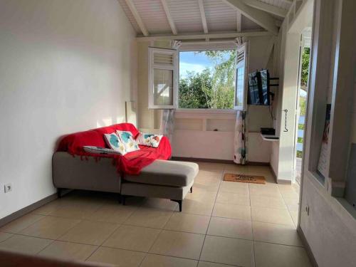 ein Wohnzimmer mit einem Sofa und einem Fenster in der Unterkunft Carbet Beaujolais in Le Vauclin