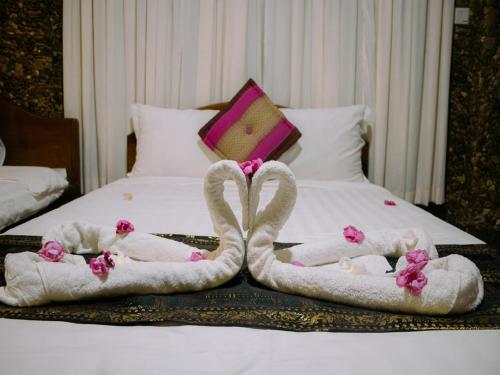 two swans made out of towels on a bed at Kep Villa Hill Guest House 1 in Kep