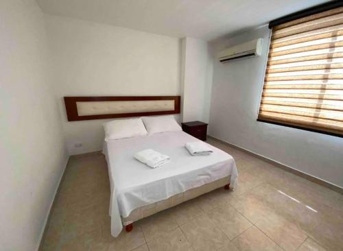 1 dormitorio con cama blanca y ventana en Apartamentos Sur de Cali cerca a Unicentro - 402 en Cali