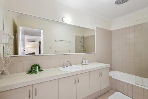 a bathroom with a sink and a mirror at Urban Apt in the Heart of Northbridge in Perth