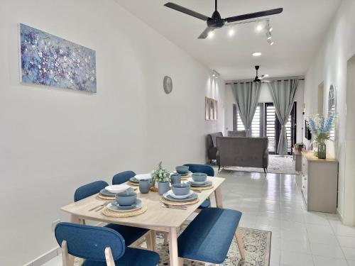 uma sala de jantar com uma mesa e cadeiras azuis em Homestay Gambang Modern vintage OZZY GUESTHOUSE em Gambang