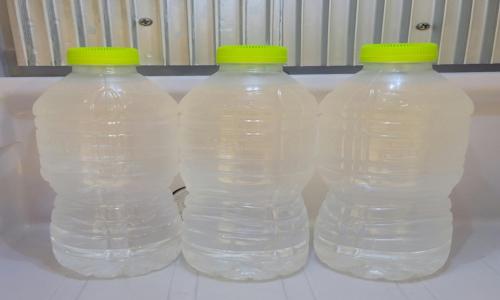 three plastic bottles of water with green tops on a table at Jinhae Pasta Hotel in Changwon