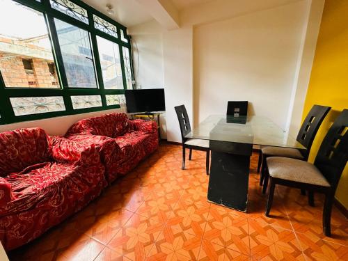 sala de estar con sofá rojo y mesa en Kayac Hostel, en Huaraz