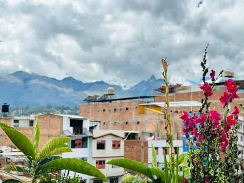 uma cidade com montanhas ao fundo com flores em Kayac Hostel em Huaraz
