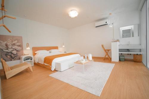 a bedroom with a bed and a table and a chair at Leye Inn in Yangshuo