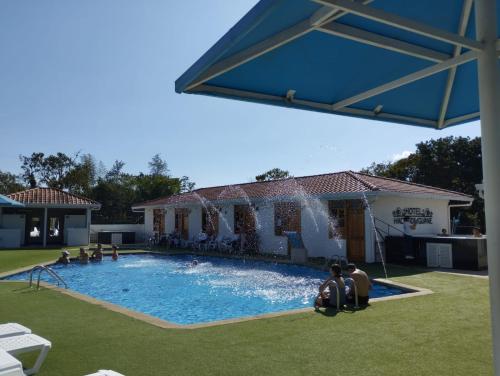 a large swimming pool with a fountain in a yard at Hotel Hacienda Guane Campestre in Oiba