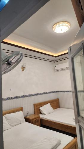 a room with two beds and a ceiling at Khách sạn An Thịnh in My Luong