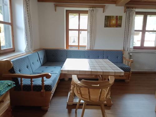 Pokój z niebieską kanapą i stołem w obiekcie Gipfelblick am Wössner Bach w mieście Unterwössen