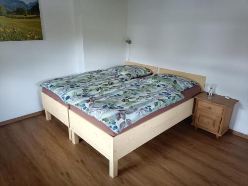 Bett in einem Schlafzimmer mit Holzboden in der Unterkunft Gipfelblick am Wössner Bach in Unterwössen