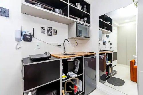een keuken met een bureau en een computer bij Loft 406 in Curitiba