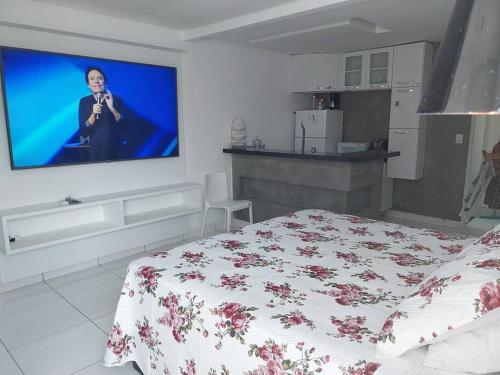 um quarto com uma cama e uma televisão na parede em Studio confortável, na Marambaia. em Belém