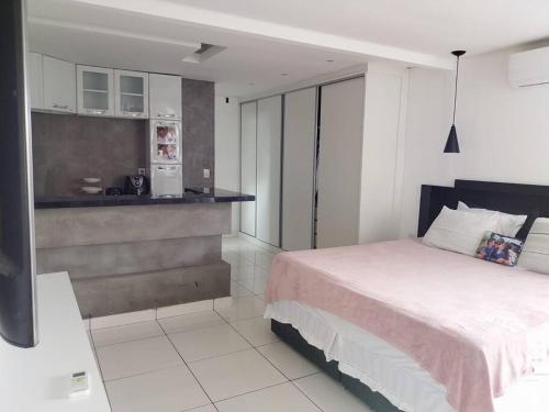 um quarto com uma cama e uma cozinha em Studio confortável, na Marambaia. em Belém