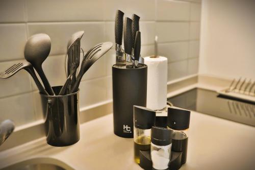 a kitchen counter with utensils in black containers on it at Luminoso Studio en Santiago Centro HOM in Santiago