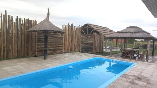 a swimming pool in a backyard with a fence and an umbrella at Quinta elescano in Junín