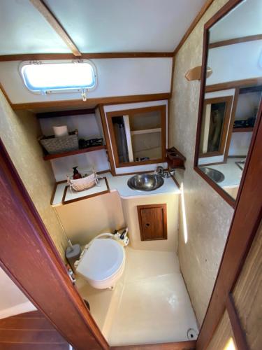 a small bathroom with a toilet and a sink at Duerme en un hermoso Velero dentro de la Marina in La Paz