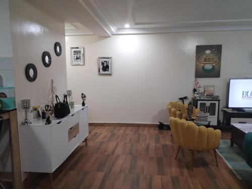 salon z białymi ścianami i drewnianą podłogą w obiekcie Appartement Elegant w mieście Konakry