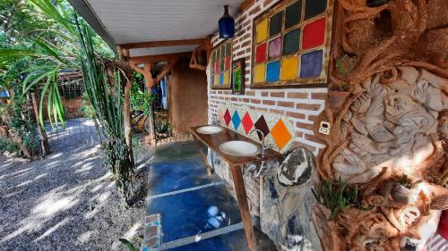 a bathroom with a sink on a brick wall at NOMADAS chales, mini casinhas, bangalôs e area de camping in Bonito