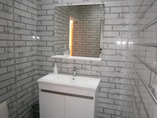 a bathroom with a white sink and a mirror at Villa isouktan in Sbiti