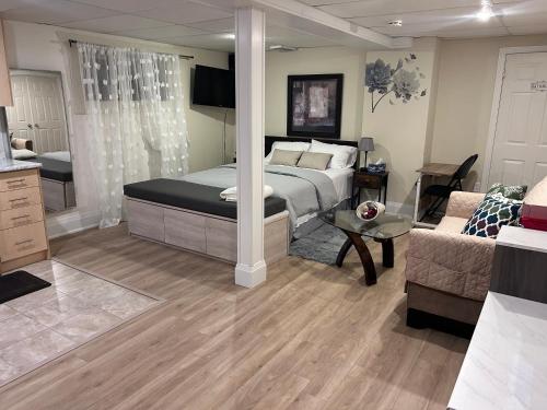 ein Schlafzimmer mit einem Bett und ein Wohnzimmer in der Unterkunft KD Bachelor Suite - Lower Level in Barrie