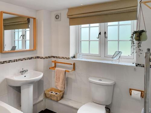 a white bathroom with a toilet and a sink at Corn Stook - 16867 in Sawdon