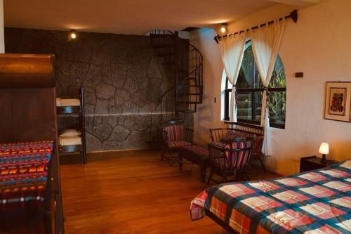 Cerro de OroにあるInlaquesh Villa Atitlánのベッドルーム1室(ベッド1台、テーブル、椅子付)