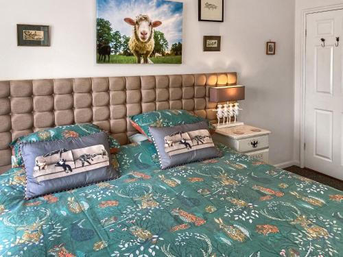 1 dormitorio con 1 cama y una foto de una oveja en Walnut Cottage en Long Melford