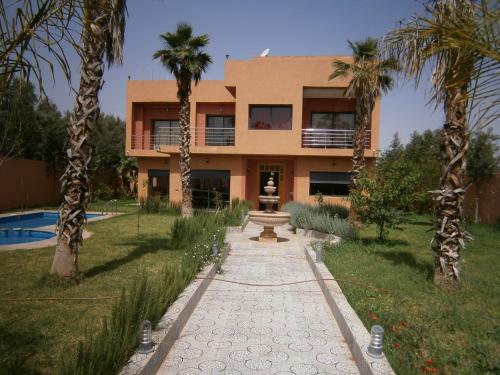 a building with palm trees in front of it at Villa isouktan in Sbiti