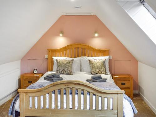 a bedroom with a wooden bed in a attic at Fraser Terrace in Leadhills