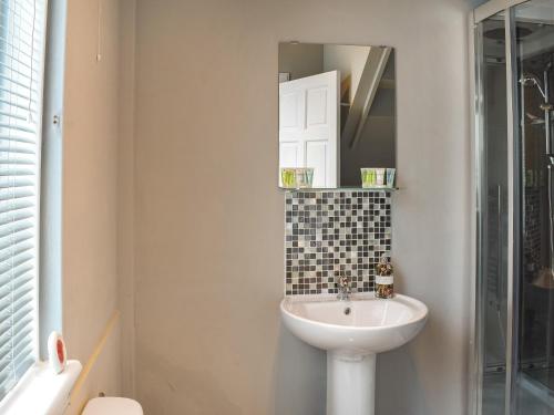 uma casa de banho com um lavatório e um espelho em Fraser Terrace em Leadhills