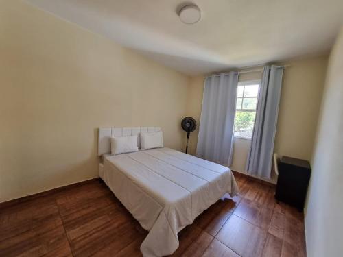 una camera da letto con un grande letto bianco e una finestra di Apart Roma l Amplo e confortável no Centro de Águas de Lindóia ad Águas de Lindóia
