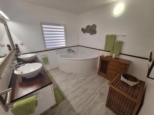 Un baño grande con bañera y lavabo. en Moorea - Fare Hanahei, en Maharepa
