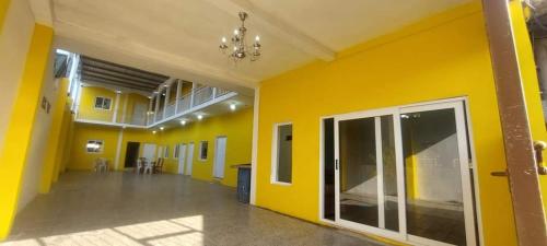 an empty room with yellow walls and a hallway at Hotel La Posada de Don Chusito in Puerto Barrios