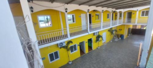 an empty building with yellow walls and balconies at Hotel La Posada de Don Chusito in Puerto Barrios