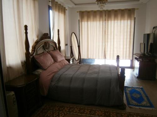 a bedroom with a bed and a mirror and a window at Villa isouktan in Sbiti