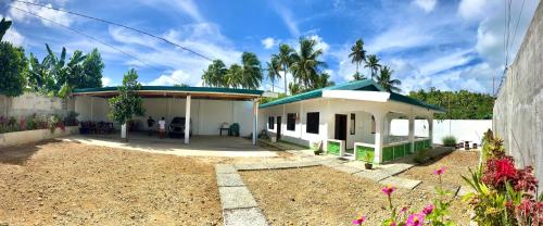 a small white house with a blue roof at NOGS Homestay, near Magpupungko, Siargao Island Surfings Spots in Pilar
