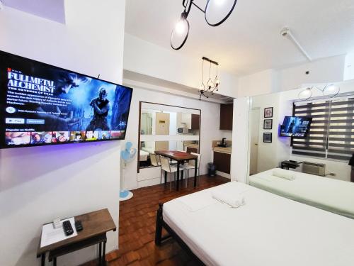 een kamer met een bed en een tv aan de muur bij Bright Makati Glass View By GreenBelt in Manilla