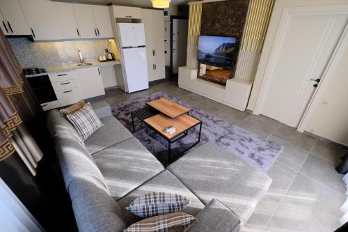 - un salon avec un canapé et une table dans l'établissement LİMONOTTO SUİT OTEL, à Çiftlikköy